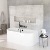 Modern white freestanding bathtub against a textured gray wall with a recessed niche holding toiletries and a wall-mounted faucet/handheld shower combo; round side table with mirror and products nearby.