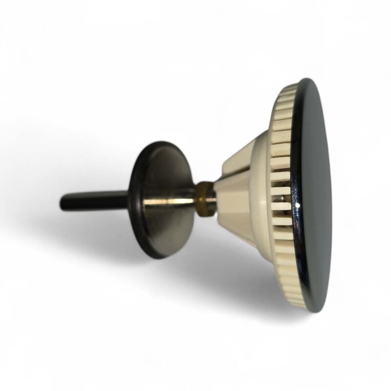 Espresso tamper with a wide flat bottom and ridged edge, used to compress coffee grounds in a portafilter, resting on its side on a white background